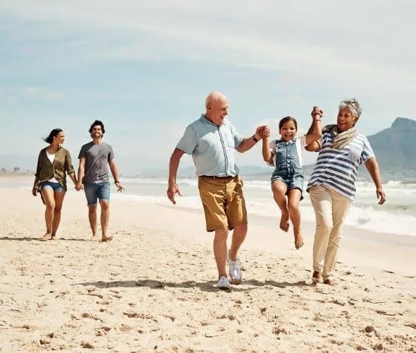 Three generations of a family enjoying a walk together on the beach